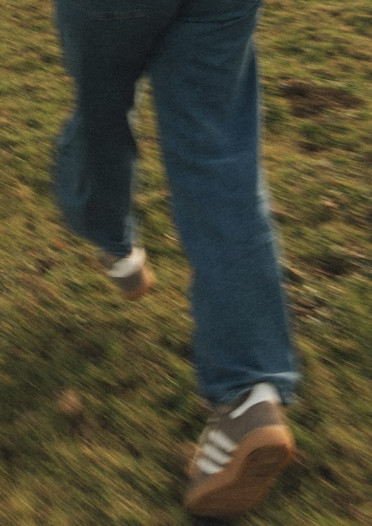Rennen über die Wiese in Jeans